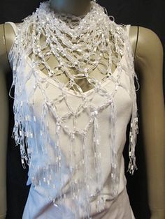 a mannequin wearing a white dress with beads on it