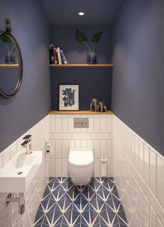 a white toilet sitting next to a sink in a bathroom under a mirror on top of a wooden shelf