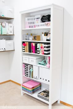 a white bookcase filled with lots of books and crafting supplies in a room