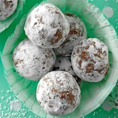 powdered sugar covered donuts in a green bowl