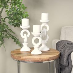 three white candles are sitting on a table