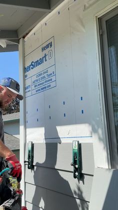 a man working on the side of a house