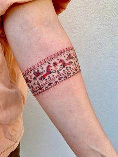 a woman's arm with a tattoo on it that is decorated with horses and flowers