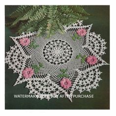 a crocheted doily with pink flowers and leaves on the bottom is shown