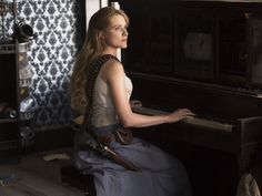 a woman sitting at a piano in a room