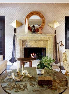 a living room filled with furniture and a fire place next to a mirror on the wall