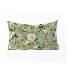 a green pillow with white and yellow flowers on it