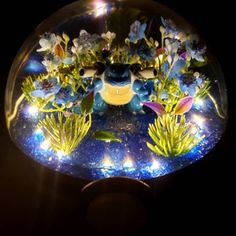 a glass ball with flowers and plants in it