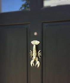 a scorpion door knocker on a black front door