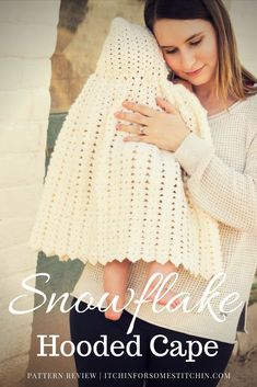 a woman holding a white crocheted blanket with the words snowflake hooded cape