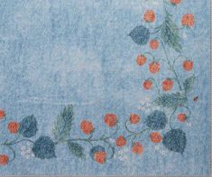 a blue rug with red flowers and leaves on it