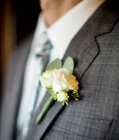 a man in a suit and tie with a boutonniere on his lapel