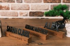 three wooden letters are placed next to a bonsai tree