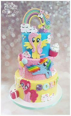 a three tiered cake decorated with rainbows and ponies