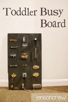 there is a black board with keys on it and the words toddler busy board above it