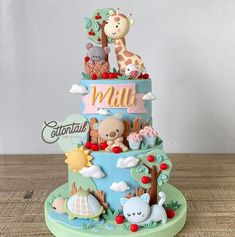 a three tiered cake decorated with animals and other things on it's side