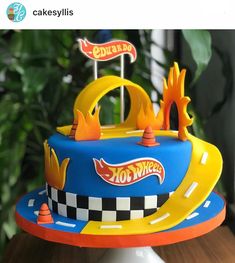 a birthday cake decorated with hot wheels and cars