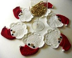 crocheted wine glass coasters with santa hats on them