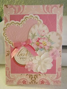 a close up of a greeting card with flowers and a heart on the front that says, i love you