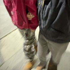 two people standing next to each other on a sidewalk