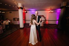 a bride and groom dance together on the dance floor