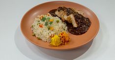 a plate with rice, meat and vegetables is shown on a white tableclothed surface