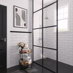 a bathroom with black and white tile walls, flooring and a glass shower door