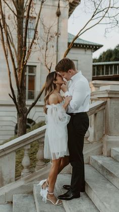 a man and woman are standing on some steps