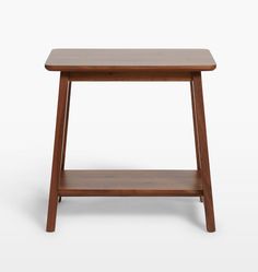 the side table is made from wood and has a small shelf on one end, which holds