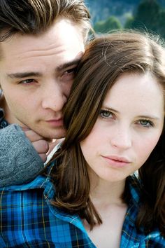 a young man and woman are posing for a black and white photo with their arms around each other