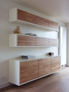 an empty room with white and wood furniture