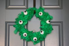 a green wreath with googly eyes on the front door