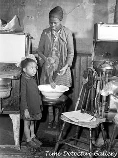 an old black and white photo of two children in a kitchen with food on the table