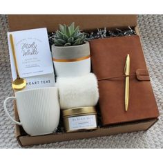 a gift box containing a mug, candle and other items