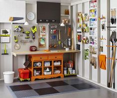 a workbench with lots of tools hanging on the wall and pegboard behind it