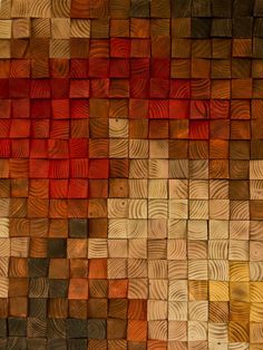 wood blocks are arranged in the shape of an abstract wall art piece, with different colors and sizes