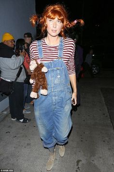 a woman in overalls holding a stuffed animal