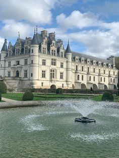 a large white building with a fountain in front of it