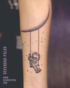 an astronaut floating in the sky on a string tattoo