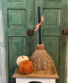 two pumpkins are sitting on top of a small table in front of green doors