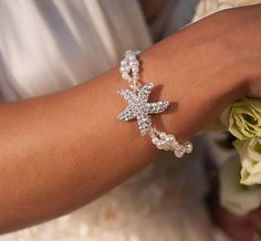 a bride's arm with a star bracelet on it