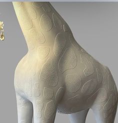 a white giraffe statue with gold accents on it's neck and legs