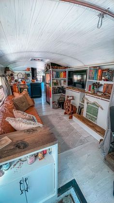 a living room filled with lots of furniture and bookshelves next to each other