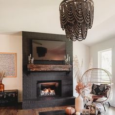 a living room filled with furniture and a chandelier hanging from the ceiling over a fire place