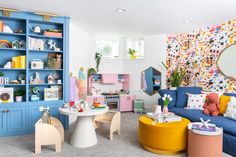 a living room filled with lots of furniture and colorful accessories on top of blue bookshelves