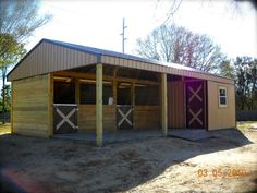 a horse barn with two stalls in the middle