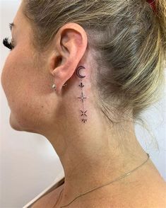 a woman with a small tattoo on her neck and behind her ear is an arrow