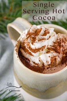 there is a cup of hot chocolate with whipped cream on top and the words single serving hot cocoa above it