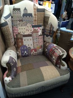 a patchwork chair with pillows on it in a store