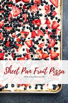 a sheet pan filled with fruit pizza topped with blueberries and strawberries